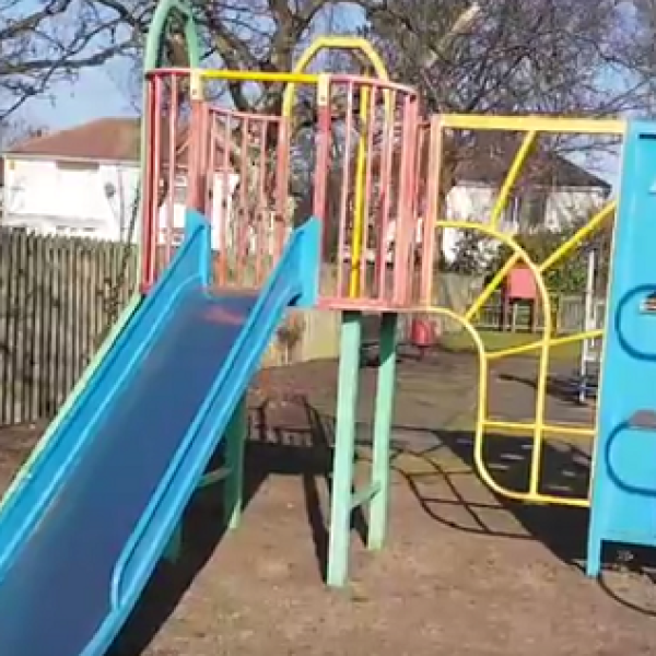 A children's play structure with a slide and climbing frame.