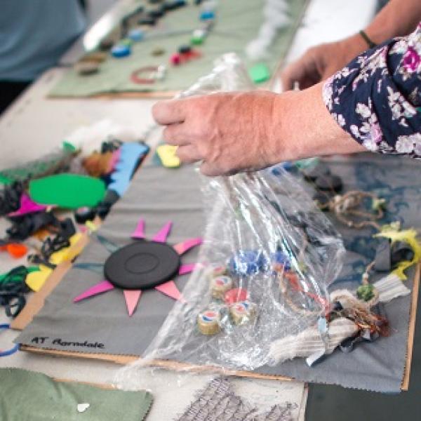 A person with various craft supplies creating some art work