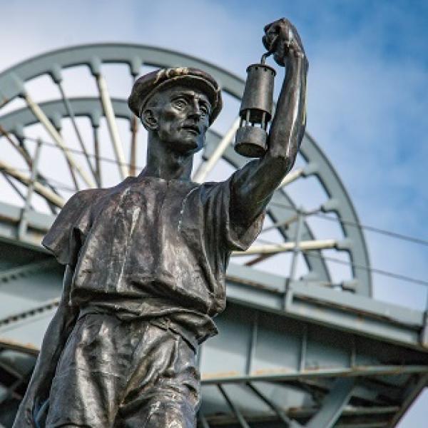 A statue of a coal miner holding a gas lamp