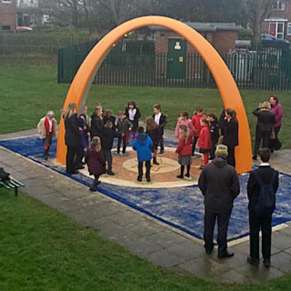SONA arch, A large orange arch with a platform. School children are standing on the platform using the arch.