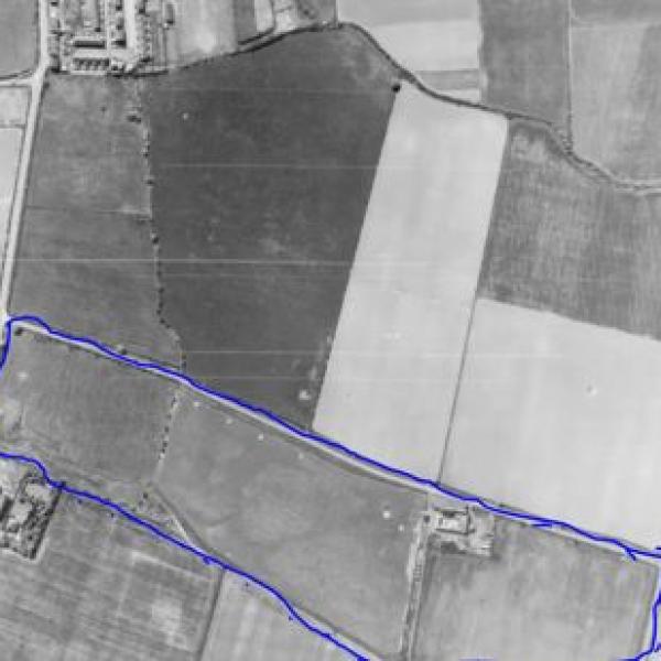 A black and white birdseye view of farm fields with a blue outline showinng where valley park is now